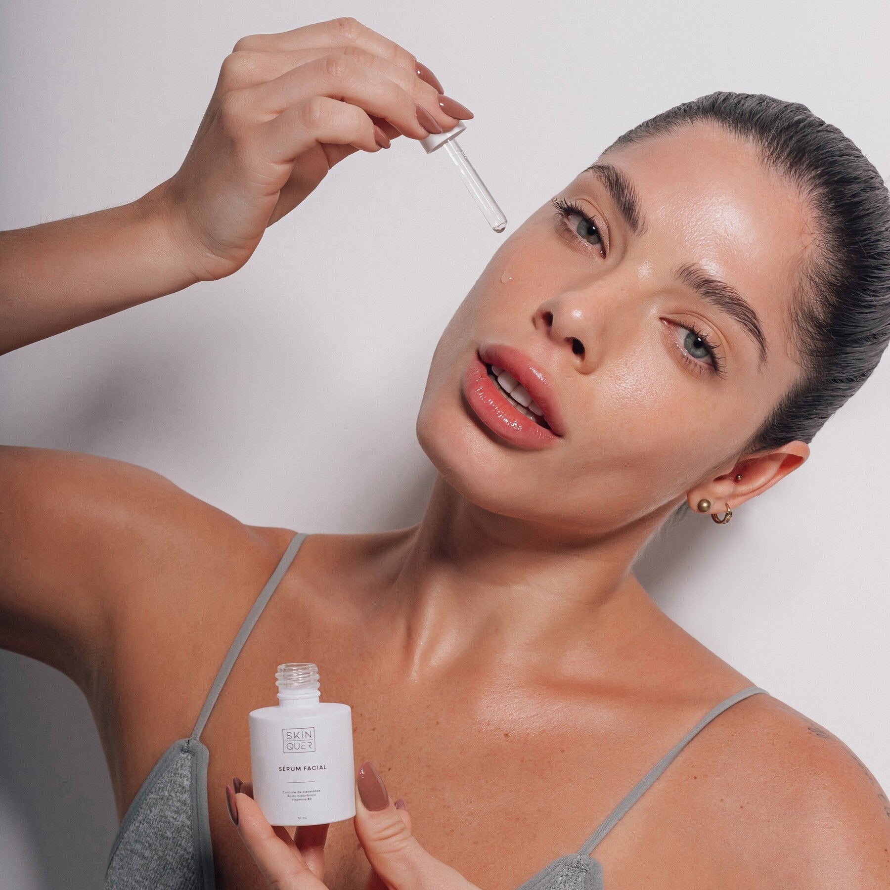 Modelo utilizando produto de skincare | Kit skincare para melhorar a pele do rosto | Produtos de alta performance, veganos e dermatologicamente testados